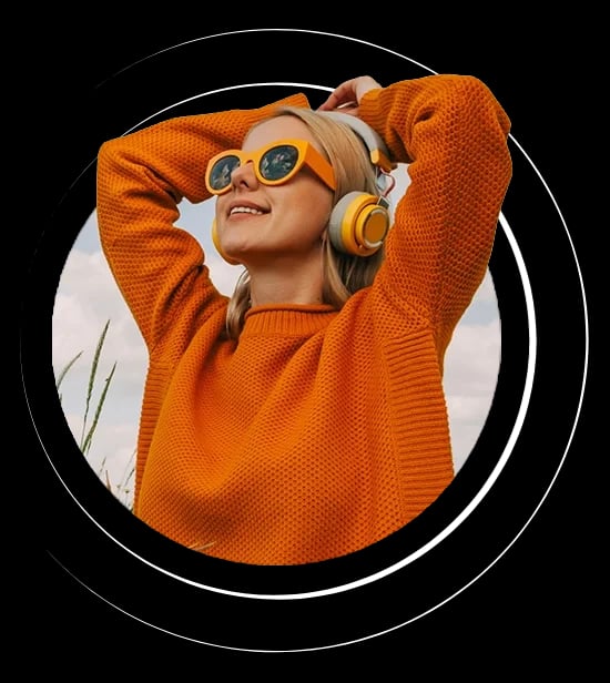Woman in orange sweater with headphones